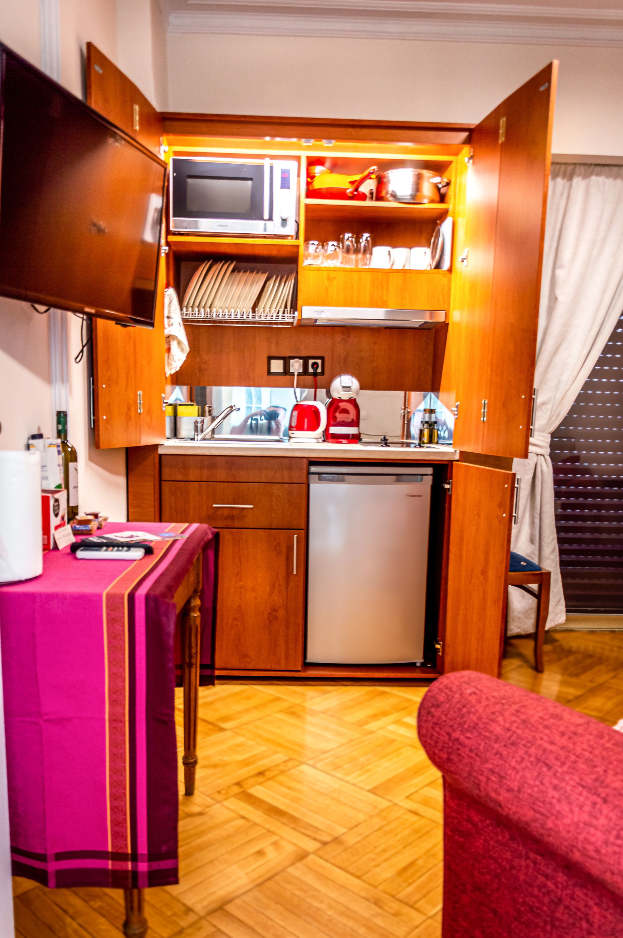 A compact kitchen with a microwave, sink, and small refrigerator.