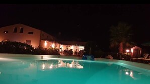 A nighttime view of a swimming pool area with a building in the background. - Seredipa (scopello) fraz Guidaloca - Studio for 2 people (Castellammare del Golfo)