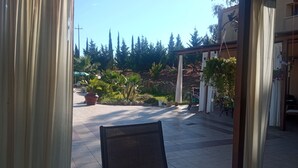 A patio area with a view of a garden, outdoor furniture, and a pergola structure. - Seredipa (scopello) fraz Guidaloca - Studio for 2 people (Castellammare del Golfo)