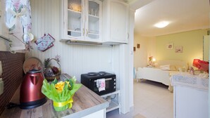 A compact kitchen with a microwave, kettle, and a small dining area. - ERATO  APARTMENT  IN ARGOSTOLI (Argostoli)