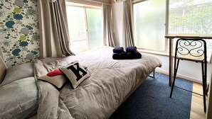A bedroom with a bed, curtains, a window, and a chair. - Home WIFI & Compact & Tranquil Apt with LOFT! (Tokyo)