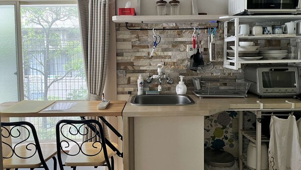 A compact kitchen with a wooden countertop, a sink, a microwave, and a toaster. There is a dining area with a table and chairs. - Home WIFI & Compact & Tranquil Apt with LOFT! (Tokyo)