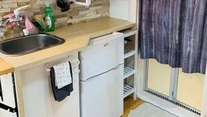 A compact kitchen with a sink, a small refrigerator, a microwave, and a window with curtains. - Home WIFI & Compact & Tranquil Apt with LOFT! (Tokyo)