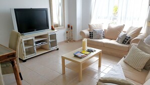 A living room with a television, a sofa, a coffee table, and a cabinet. - Luxury apartment in Los Alisios (Santa Cruz de Tenerife)