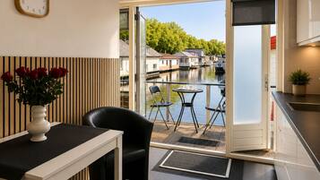 A modern kitchen with a view of a canal and houses.