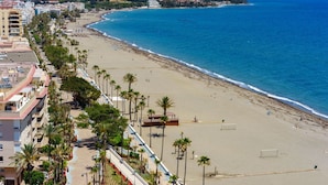 A coastal cityscape with a beach, buildings, and mountains in the background. - Nice apartment for 4 guests with A/C, pool, WIFI, TV and terrace (Estepona)