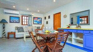 Un coin repas comprenant une table ronde, des chaises et un buffet bleu avec des tiroirs.