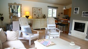 A living room with a sofa, two armchairs, a coffee table, and a fireplace. - Comfortable house, big pool with wooden terrace, ideal location (Lacanau)