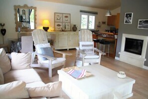 A living room with a sofa, two armchairs, a coffee table, and a fireplace. - Comfortable house with pool G0269 (Lacanau)