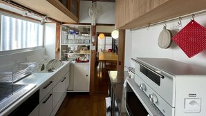 Een kleine keuken met houten kastjes, een inbouwoven en een magnetron.