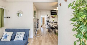 Een woonkamer met een blauwe bank en een spiegel aan de muur.