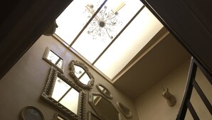 A staircase with a view of the ceiling and various mirrors on the wall. - A relaxed,  comfortable and cosy home (Chef Boutonne)