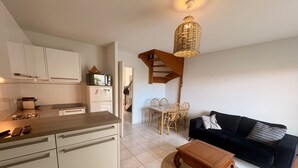 A compact living space with a kitchenette, dining area, and a sofa.