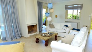 Ein Wohnzimmer mit einem weißen Sofa, einem Holztisch und einem Kamin.