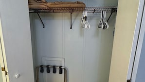 Une buanderie équipée d’un étendoir métallique, d’un séchoir et d’un panier à linge.