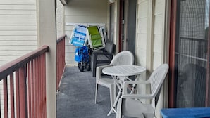 Un espace extérieur abrité, doté d’une rambarde, d’une table et de chaises.