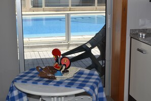 Enjoy a balcony with a pool view, featuring a table and comfortable seating.
