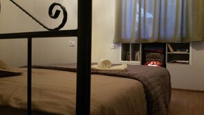 A bedroom with a bed, a window with curtains, and a bookshelf with books. - The Librarians' Flat (Dzveli Tbilisi)