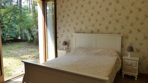 Une chambre à coucher avec un lit, deux tables de chevet et une fenêtre.