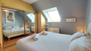 Un dormitorio con una cama grande, un espejo, un tragaluz y un radiador.