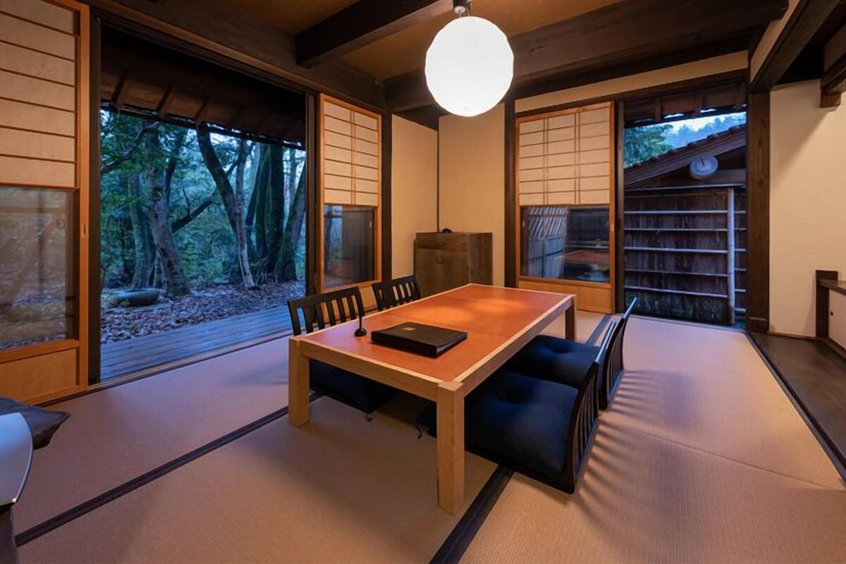A traditional Japanese-style room with tatami flooring, a low table, and sliding doors.