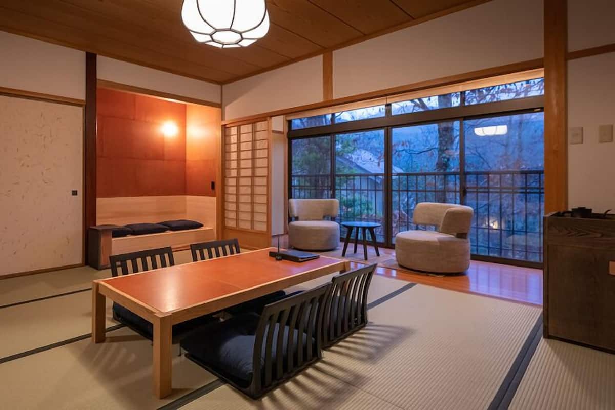 A traditional Japanese room with tatami flooring, a low wooden table, and a sliding door.