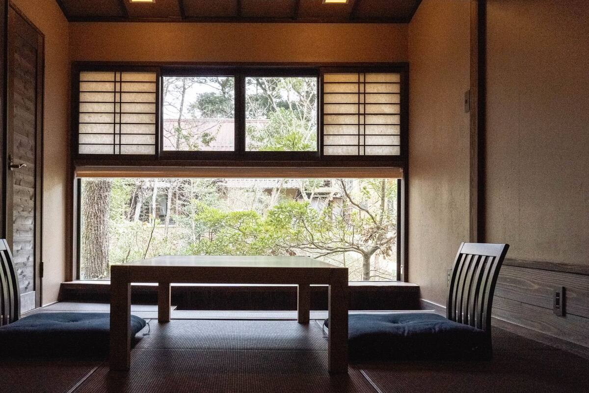 A traditional Japanese room with tatami flooring, a low table, and shoji screens.