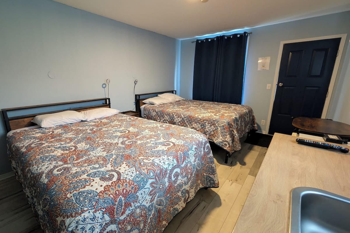 A room with two beds, a desk, and a chair.