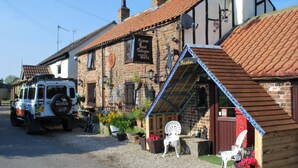 Un edificio tradicional con un letrero que dice 'Yarm Guest Cottages'.