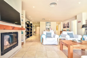 Flachbildfernseher, Kamin, Bücher, Stereoanlage