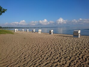 A beach with six white beach huts aligned in a row along the shoreline. - 2 room duplex apartment near the beach Wohlenberger Wiek near Boltenhage Baltic Sea (Niendorf)