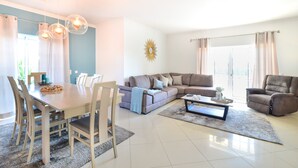 A modern living room with a dining area, a sectional sofa, and a coffee table.