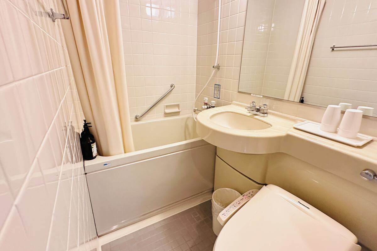 Un baño con bañera, lavabo, inodoro y espejo.