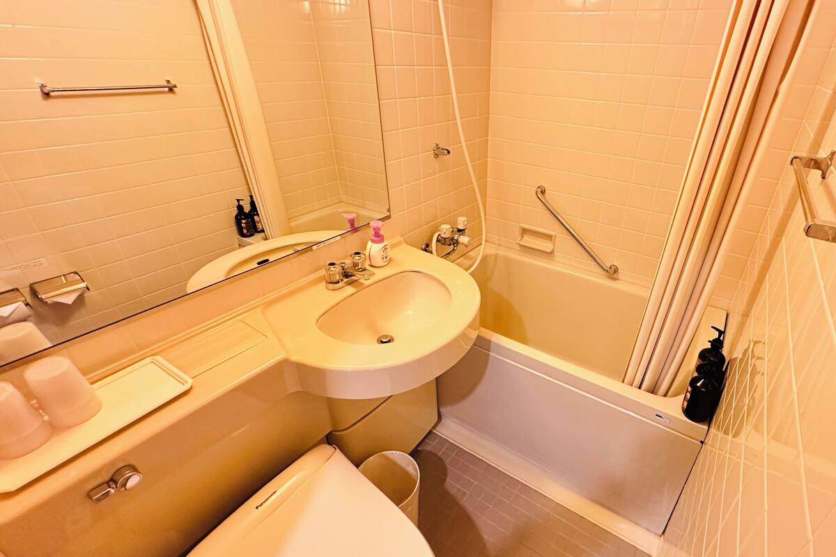 Un baño con lavabo, espejo, inodoro y bañera.