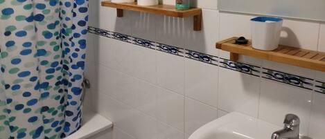 Tina con regadera, secadora de cabello, bidet, toallas