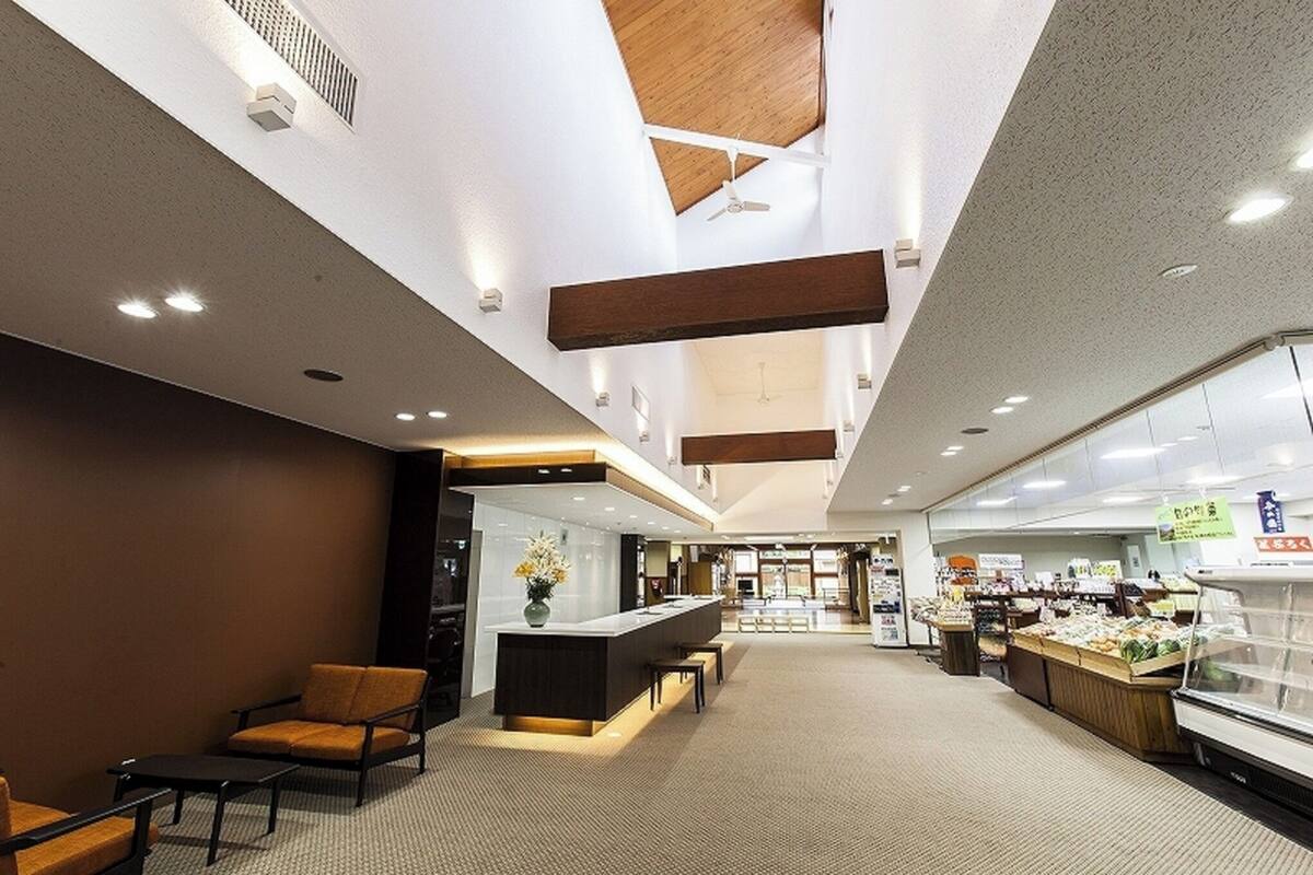 Eine großzügige Lobby mit einer Rezeption, einer Sitzecke und einer Speisenauslage.