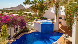 A private pool with a hot tub, surrounded by lush greenery and a mountain view. - Pedregal Villa w/ Pool, Hot Tub, Walk to Town, Near Swim Beach & Ocean Views (Cabo San Lucas)