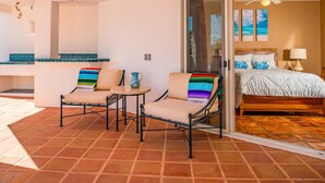 A room with a bed, a sofa, and a chair with a small table. There is a sliding glass door leading to a balcony. - Pedregal Villa w/ Pool, Hot Tub, Walk to Town, Near Swim Beach & Ocean Views (Cabo San Lucas)