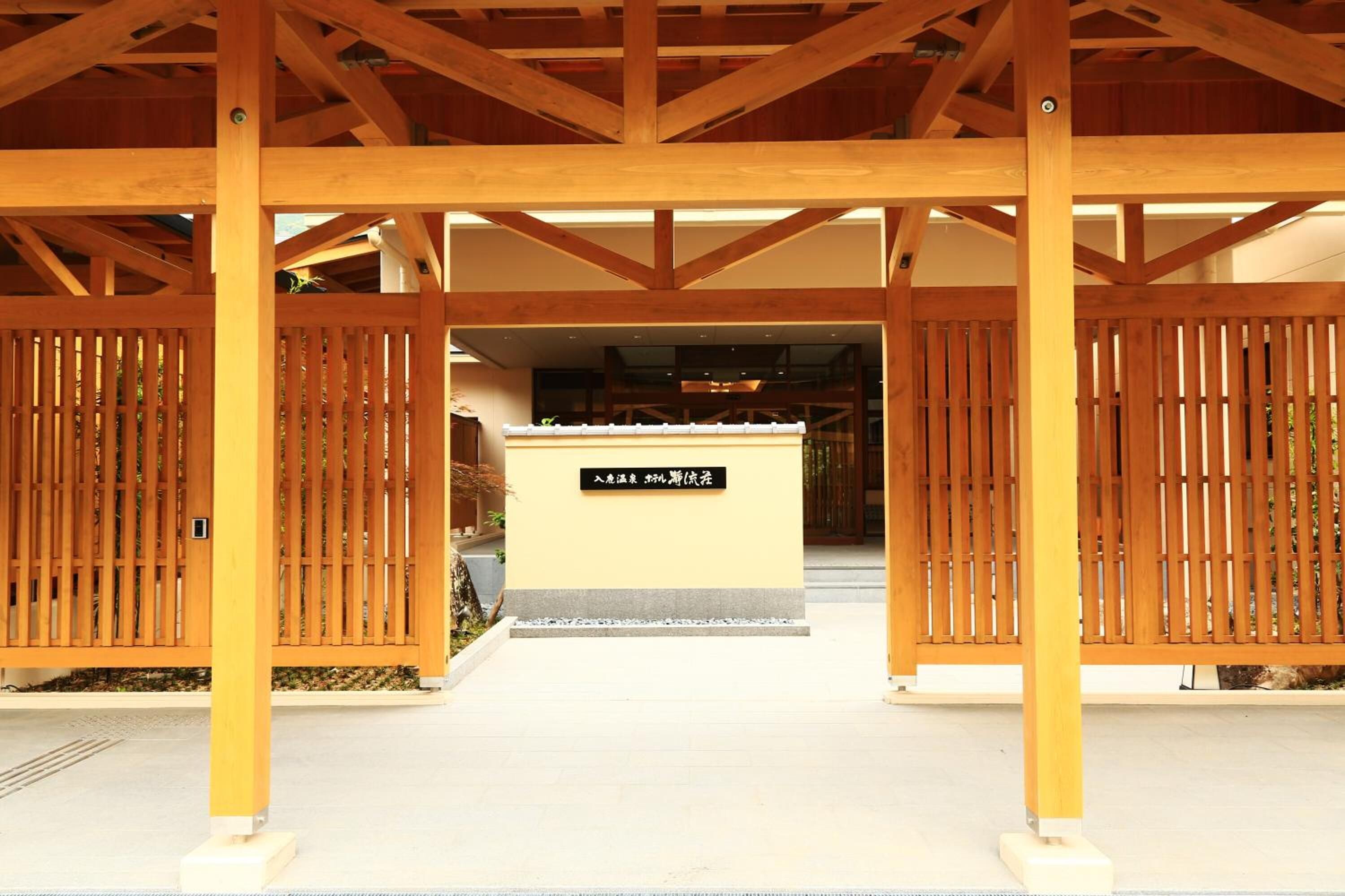 En traditionell japansk entré med träportar och en skylt framför.