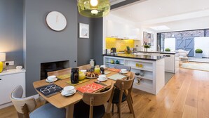 Una cocina moderna con comedor, que incluye una zona de desayuno con tazas, platos y una cafetera.