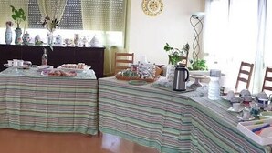 Uma área de refeições com toalhas de mesa listradas, um espaço para café e diversos objetos decorativos.