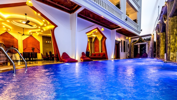Una piscina con una zona de estar roja y un ventilador de techo.