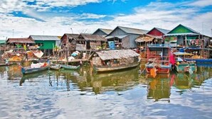Un pueblo flotante con casas tradicionales y barcos.