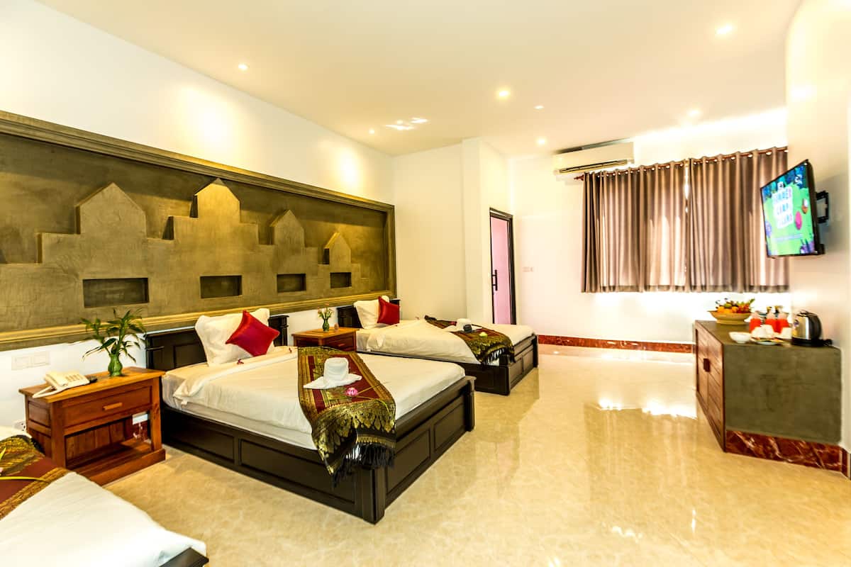 Una habitación de hotel con dos camas, una obra de arte grande en la pared, un televisor y un minibar.