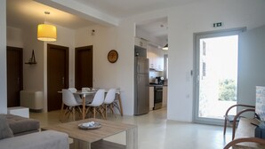 Eine moderne Wohnung mit Essbereich, Küche und einem Balkon.