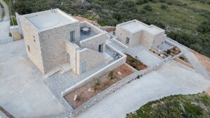 Eine moderne Villa mit Steinaußenwand, mehreren Zimmern und einer Terrassenfläche.