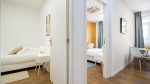 Une chambre d’hôtel comprenant un lit, une table de chevet et un bureau avec une chaise.