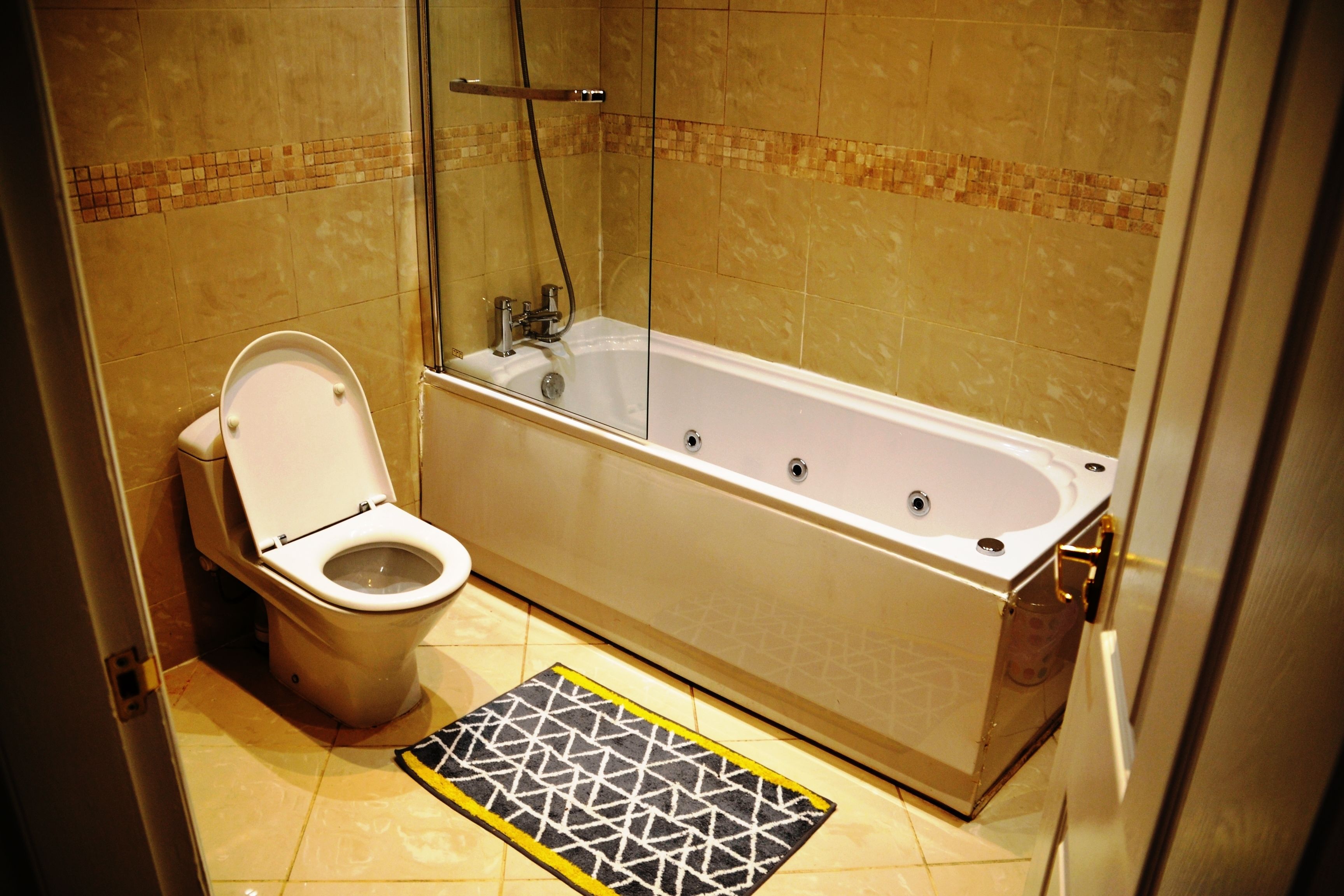 A bathroom with a toilet, a bathtub, and a shower.