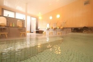 An indoor swimming pool with tiled walls, a wooden floor, and a bench along the wall. - Chalet Nakanishi (Takayama)