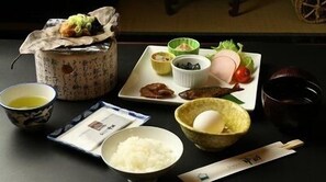 A traditional Japanese meal setup with a bowl of rice, a cup of tea, and various dishes on a table. - Chalet Nakanishi (Takayama)